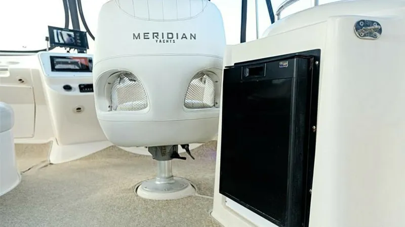 Slide: The Image of Helm Seating and Dashboard View The image showcases the helm area of the 2006 Meridian 391 Sedan, featuring a comfortable captain's chair with the Meridian logo. The dashboard is equipped with modern navigation instruments, ensuring a smooth sailing experience. The clean lines and ergon - 7766936