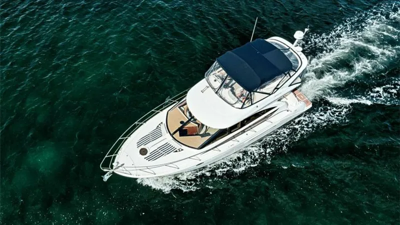 Slide: The Image of Aerial View of Flybridge and Bow This 2006 Meridian 391 Sedan is captured from above, showcasing its spacious flybridge with a sleek, navy canopy. The expansive bow area features a sunpad, perfect for relaxation and sunbathing. The yacht cuts elegantly through the water, exemplifying its - 7766958