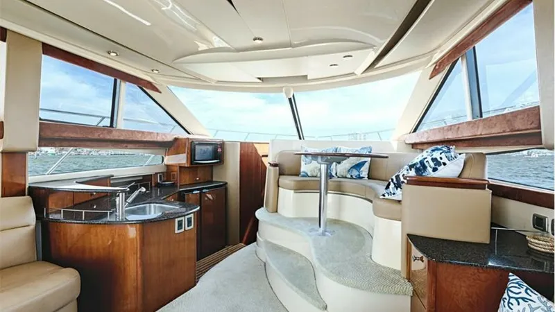 Slide: The Image of Spacious Salon with Panoramic Views The 2006 Meridian 391 Sedan's salon offers a luxurious space with expansive windows providing panoramic views. The elegant seating area and compact galley are beautifully integrated, featuring rich wood finishes and plush upholstery. Natural light floods - 7766924