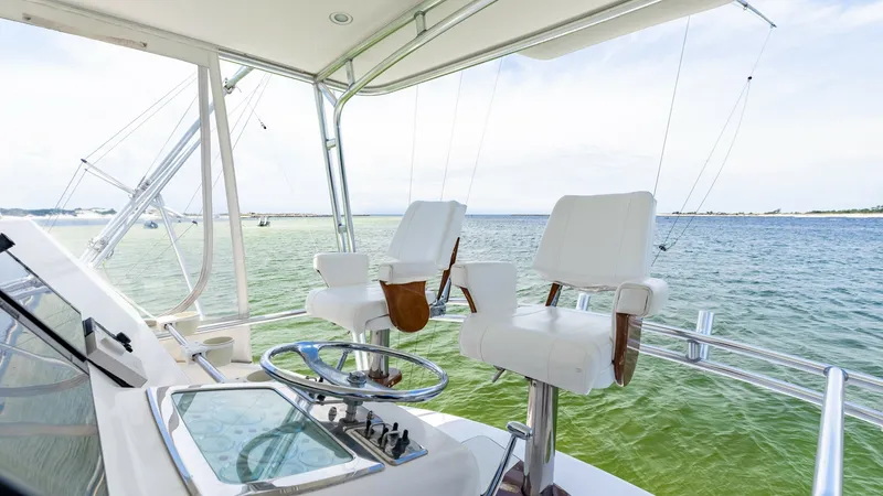 Slide: The Image of Flybridge Helm with Dual Seating The flybridge helm of the 2003 Cabo 43 Convertible features dual captain's chairs offering commanding views of the surrounding waters. The helm is equipped with essential navigation controls and a sleek steering wheel for easy maneuvering. Ample space and - 7831808