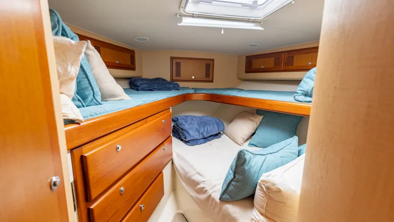 Slide: The Image of Cozy Forward Stateroom with Twin Berths This inviting forward stateroom features a well-organized layout with twin berths, providing ample sleeping space. The warm wood finishes and built-in cabinetry offer both style and functionality, while the overhead hatch allows natural light to illuminat - 7831802
