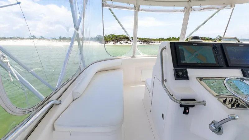Slide: The Image of Flybridge Helm with Seating Area The flybridge of the 2003 Cabo 43 Convertible features a well-appointed helm with advanced navigation displays and controls, providing excellent visibility and command. A comfortable bench seating area allows for relaxation and socializing while enjoying - 7831806