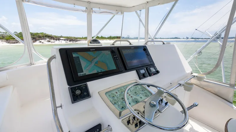 Slide: The Image of Flybridge Helm with Navigation Displays The flybridge helm of the 2003 Cabo 43 Convertible features dual navigation displays for precise control and guidance. The sleek steering wheel and intuitive control panel create an efficient and comfortable piloting experience. Surrounded by panoramic vi - 7831805