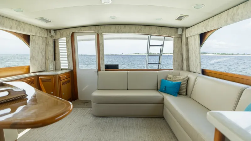 Slide: The Image of Salon with Panoramic Windows This inviting salon on the 2003 Cabo 43 Convertible features plush L-shaped seating and panoramic windows offering stunning ocean views. The neutral tones create a serene atmosphere, complemented by elegant wood finishes and contemporary decor. An open la - 7831788