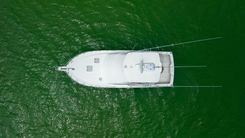 Slide: The Image of Aerial View of Flybridge and Deck This aerial shot captures the sleek design of the 2003 Cabo 43 Convertible's flybridge and deck. The spacious deck offers ample room for fishing or relaxing, while the flybridge provides a commanding view for navigation. The vessel's streamlined profile i - 7831819