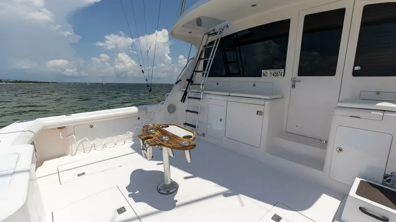 Slide: The Image of Spacious Aft Deck with Tackle Station The aft deck of the 2003 Cabo 43 Convertible 'Chao Bella' offers a well-designed space perfect for fishing enthusiasts. Featuring a sturdy tackle station, ample storage, and easy access to the flybridge via a convenient ladder, this area is both functiona - 7831812