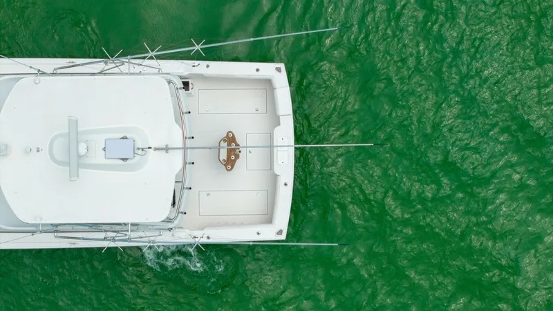 Slide: The Image of Aerial View of Aft Deck This aerial shot captures the spacious aft deck of the 2003 Cabo 43 Convertible. The deck is designed for both leisure and sport fishing, featuring robust rod holders and ample space for angling activities. The clean lines and durable materials highlight - 7831815