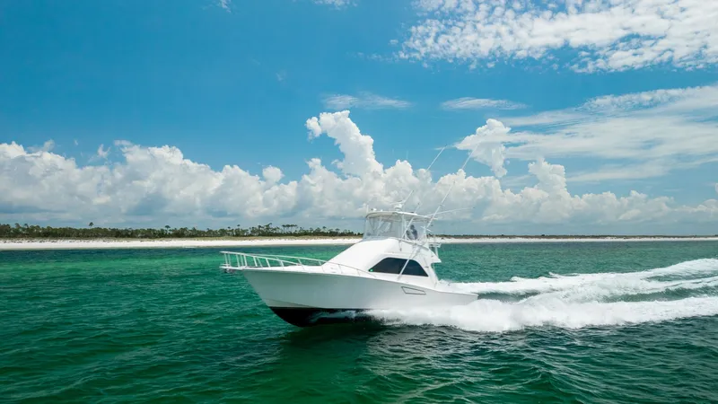 Slide: The Image of Side View Cruising at Sea The 2003 Cabo 43 Convertible, Chao Bella, cruises elegantly through pristine waters, showcasing its sleek hull design and powerful performance. The vessel's robust structure is complemented by a spacious flybridge, ideal for commanding views and navigatio - 7831824