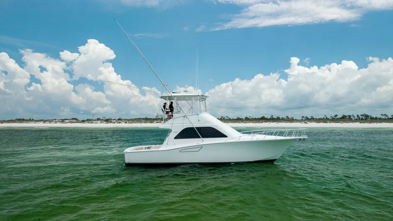 Slide: The Image of Side Profile of Cabo 43 Convertible This image showcases the sleek side profile of the 2003 Cabo 43 Convertible, 'Chao Bella'. The vessel's elegant lines and robust structure are highlighted against a serene seascape. The flybridge and expansive deck space are ideal for both relaxation and - 7831816