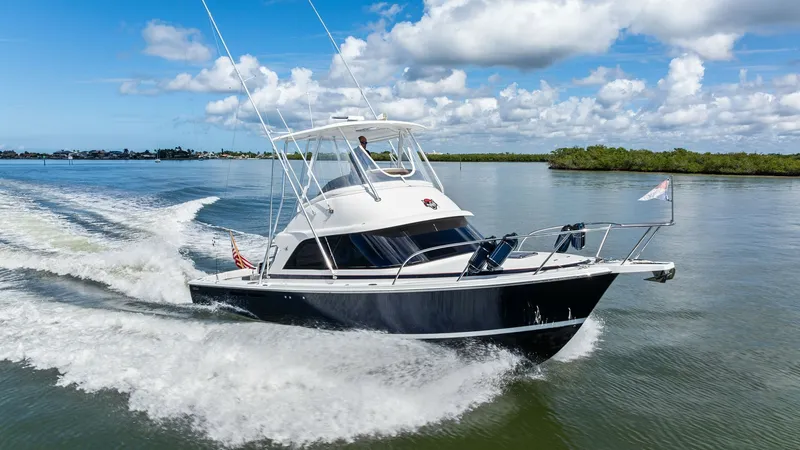 Slide: The Image of 35 Flybridge Cruising on Open Water The 2019 Bertram 35 Flybridge, Loco Lobo Del Mar II, is showcased cruising effortlessly across open waters. The vessel's sleek, dark hull contrasts beautifully with the bright, spacious flybridge, offering commanding views for navigation. Its robust desig - 7851551