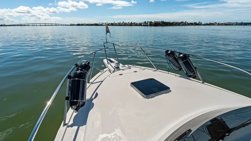 Slide: The Image of Bow View with Anchor Locker The bow of the 2019 Bertram 35 Flybridge showcases a sleek and spacious deck, ideal for relaxation and enjoying the views. The neatly integrated anchor locker and stainless-steel railings enhance both functionality and safety. With clear skies and calm wa - 7851544