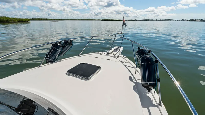 Slide: The Image of Bow Deck with Scenic Water View The bow deck of the 2019 Bertram 35 Flybridge features a sleek, unobstructed layout perfect for enjoying panoramic water views. Equipped with sturdy railings and fenders, the deck provides safety and convenience while navigating. The hatch offers easy acc - 7851541