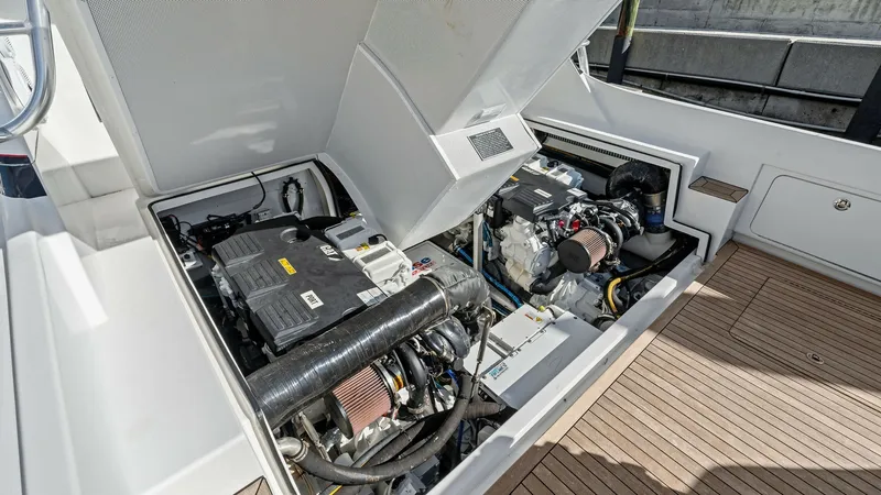 Slide: The Image of Engine Compartment with Twin Engines This image showcases the engine compartment of the 2019 Bertram 35 Flybridge, featuring dual high-performance engines. The compartment is meticulously organized, with easy access for maintenance and inspection. The clean layout and quality construction re - 7851546