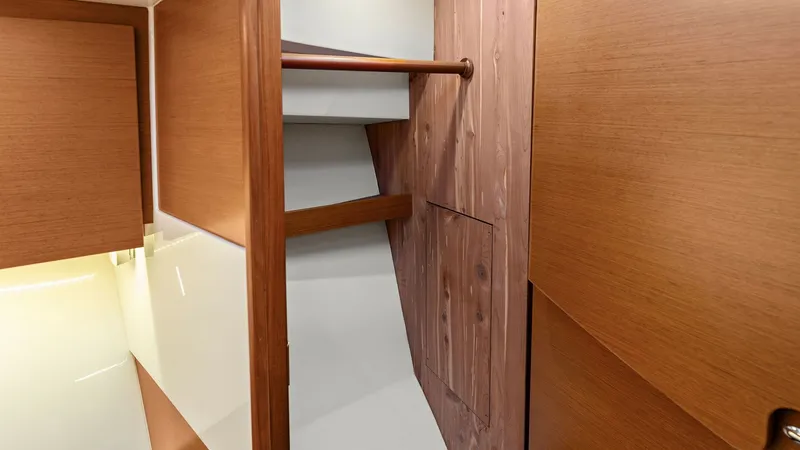 Slide: The Image of Interior Stairwell and Storage Area This image showcases the interior stairwell and storage area of the 2019 Bertram 35 Flybridge. The use of rich wood finishes creates a warm and inviting ambiance, complemented by sleek, modern lines. Thoughtfully designed for practicality, this space incl - 7851534