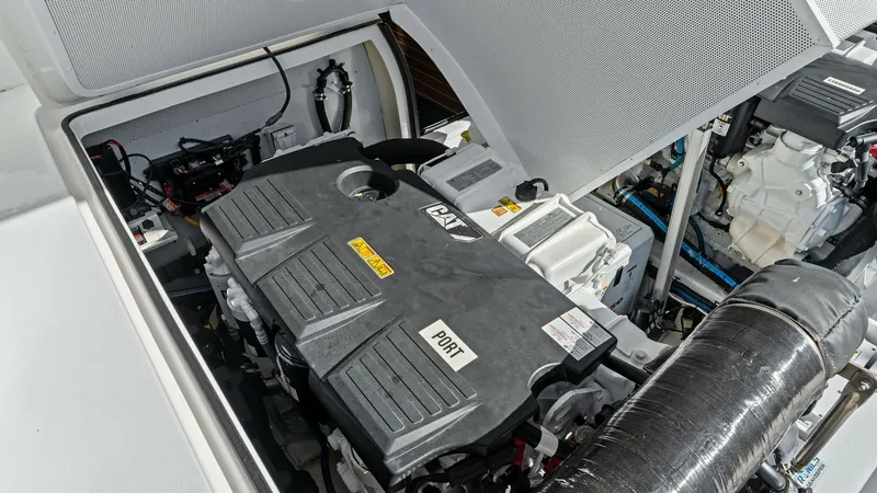 Slide: The Image of Engine Room with CAT Engines The engine room of the 2019 Bertram 35 Flybridge showcases powerful CAT engines, known for reliability and performance. The space is well-organized, featuring essential components and systems for efficient operation. The clean layout and quality engineeri - 7851547