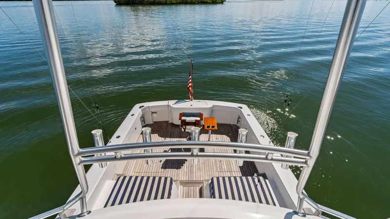 Slide: The Image of Aft Deck View from Flybridge This image showcases the aft deck of the 2019 Bertram 35 Flybridge, Loco Lobo Del Mar II, as seen from the flybridge. The spacious deck features elegant teak flooring and is equipped with comfortable seating, perfect for relaxation or entertaining guests. - 7851537