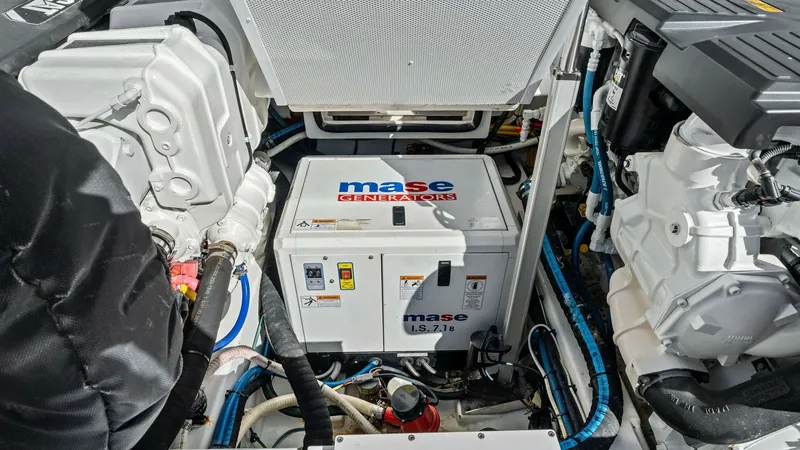 Slide: The Image of Engine Room with Generator View The image showcases the engine room of the 2019 Bertram 35 Flybridge, featuring a prominently placed Mase generator. The setup is efficient and well-organized, with clear access to essential components for maintenance. High-quality materials and precise e - 7851549