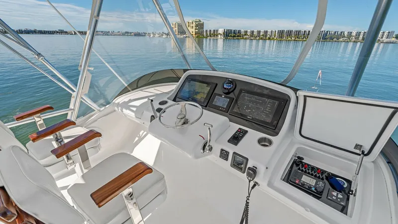 Slide: The Image of Flybridge Helm with Dual Seating The flybridge helm of the 2019 Bertram 35 Flybridge features dual seating with sleek white upholstery and elegant wooden armrests. The state-of-the-art dashboard is equipped with advanced navigation systems and controls, providing a commanding view of the - 7851535