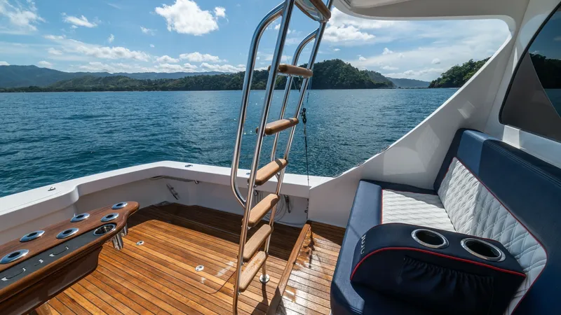 Slide: The Image of Aft Deck with Ladder and Seating The aft deck of the 2020 Viking 46 BF 'JUJU' showcases a beautifully finished teak floor with a sleek seating arrangement. The space is equipped with a ladder leading to the flybridge, enhancing accessibility and providing stunning views. The plush seatin - 7854765