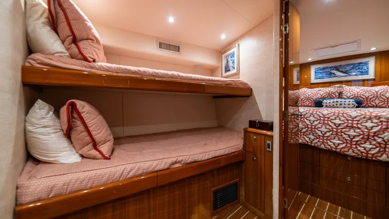 Slide: The Image of Guest Cabin with Twin Bunks The guest cabin features cozy twin bunk beds with plush bedding, offering a comfortable retreat for guests. The warm wood finishes and softly lit ambiance enhance the inviting atmosphere. A glimpse into the adjoining room reveals additional sleeping quart - 7854757