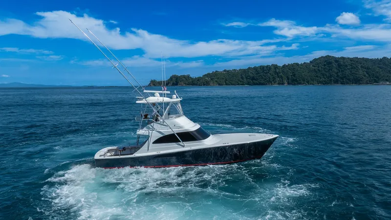 Slide: The Image of Viking 46 BF Cruising Side View This image showcases the sleek profile of the 2020 Viking 46 BF, named JUJU, navigating through open waters. The vessel's aerodynamic design and robust construction are accentuated by its glossy finish and striking lines. The flybridge provides excellent - 7854779