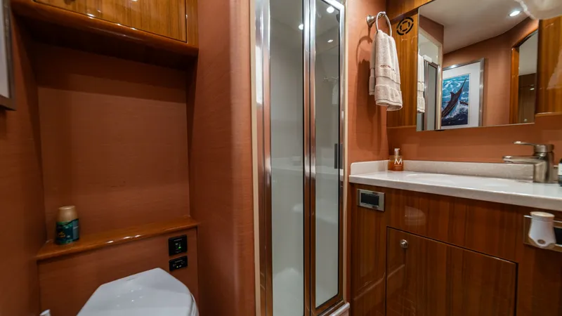 Slide: The Image of Elegant En-Suite Bathroom This luxurious en-suite bathroom on the Viking 46 BF features high-gloss wood cabinetry and a sleek, modern design. The spacious shower is enclosed with glass doors, complementing the elegant vanity with ample countertop space. Soft lighting and polished - 7854759
