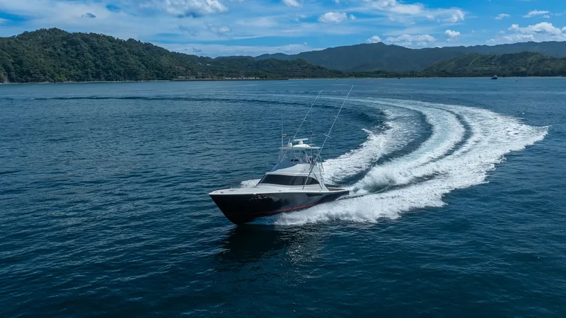 Slide: The Image of Viking 46 BF Cruising at Sea The Viking 46 BF 'JUJU' is showcased gracefully cruising through open waters, leaving a striking wake behind. This 2020 model displays its sleek design and powerful performance, ideal for offshore adventures. The stunning backdrop of lush hills and clear - 7854782