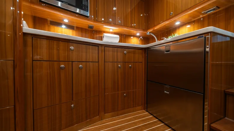 Slide: The Image of Galley with Wood Cabinetry The galley of the Viking 46 BF features exquisite wood cabinetry complemented by sleek stainless steel appliances. Under-cabinet lighting enhances the warm, inviting atmosphere, while ample storage and counter space offer practicality for onboard meal pre - 7854755