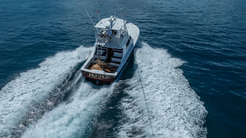 Slide: The Image of Aerial View of Aft Deck and Wake The Viking 46 BF 'JUJU' showcases a spacious aft deck designed for both fishing and leisure, highlighted by a sleek, modern design. The vessel cuts through the water effortlessly, leaving a dynamic wake, emphasizing its powerful performance. The elevated - 7854785