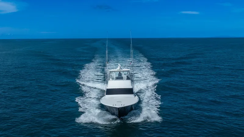Slide: The Image of Aerial View of Bow Underway This dynamic aerial shot captures the Viking 46 BF, 'JUJU', slicing through the open ocean. The sleek bow design enhances hydrodynamic performance, while the expansive flybridge offers commanding views for navigation. The vessel's powerful wake highlights - 7854783