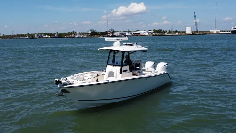 Slide: The Image of Cobia 280 Center Console Exterior The 2023 Cobia 280 Center Console showcases a sleek, modern hull design perfect for both fishing and leisure. Equipped with twin outboard engines, this vessel offers impressive power and performance on the water. The spacious deck features a robust T-top - 7927765