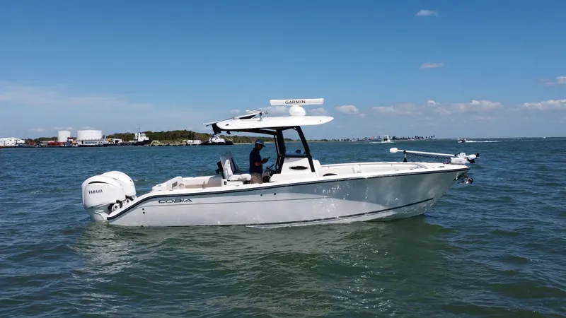 Slide: The Image of Side View of 2023 Cobia 280 The 2023 Cobia 280 Center Console showcases its sleek hull and modern design, perfect for both fishing and leisure. Equipped with twin Yamaha outboard engines, it promises powerful performance on the water. The spacious deck offers ample seating and advan - 7927760