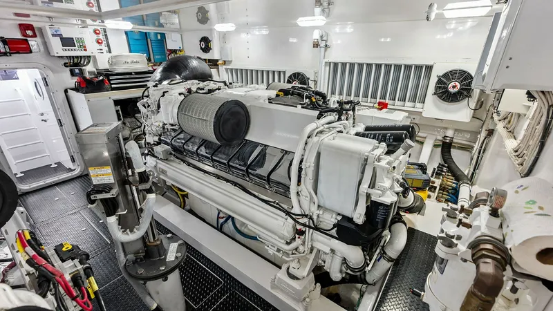 Slide: The Image of Engine Room with Twin Engines The engine room of the 2017 Viking 80 Convertible showcases robust twin engines, meticulously maintained for peak performance. The space is well-organized, featuring high-quality materials and advanced systems for efficient operation. Bright lighting and - 7932709