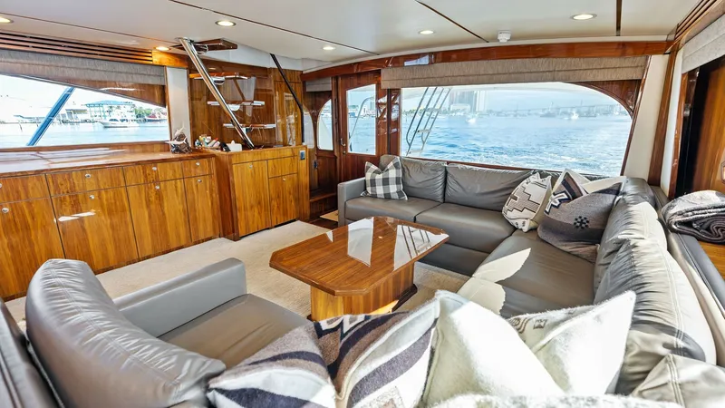 Slide: The Image of Spacious Main Salon with Ocean Views The main salon of the Viking 80 Convertible 'Aussie Rules' is elegantly designed for relaxation and entertainment. It features plush, wrap-around leather seating complemented by a polished wooden coffee table, creating a welcoming ambiance. Large windows - 7932648