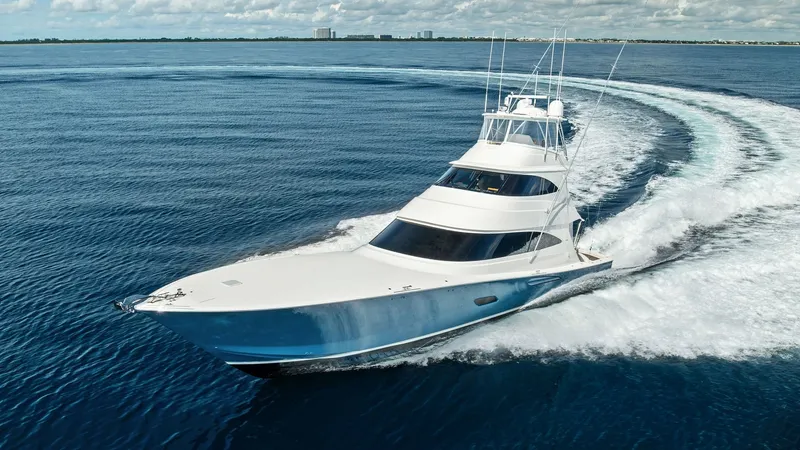 Slide: The Image of Aerial View of Viking 80 Convertible This stunning aerial shot captures the sleek design of the 2017 Viking 80 Convertible, 'Aussie Rules.' The yacht is seen cutting through the water with precision, showcasing its powerful performance and elegant lines. The flybridge and spacious deck areas - 7932724