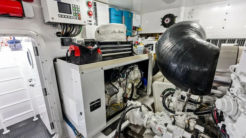 Slide: The Image of Engine Room with Generator The engine room of the 2017 Viking 80 Convertible 'Aussie Rules' showcases a well-organized, state-of-the-art setup. Dominated by a powerful generator, this space features clean, accessible wiring and control panels for efficient operation. The bright, we - 7932712