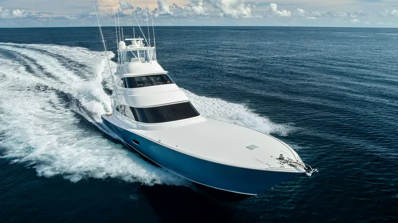 Slide: The Image of Aerial View of Bow Underway This stunning aerial view captures the Viking 80 Convertible's sleek bow slicing through the water with power and grace. The pristine white hull contrasts beautifully against the deep blue ocean, showcasing its impressive seakeeping abilities. The vessel' - 7932727