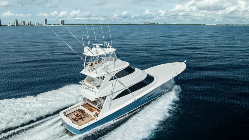 Slide: The Image of Aerial View of Sportfish Yacht in Motion This dynamic aerial shot captures the Viking 80 Convertible 'Aussie Rules' slicing through the water with grace and power. The vessel's sleek design is accentuated by its expansive flybridge and classic sportfishing lines. The spacious aft deck is perfect - 7932728