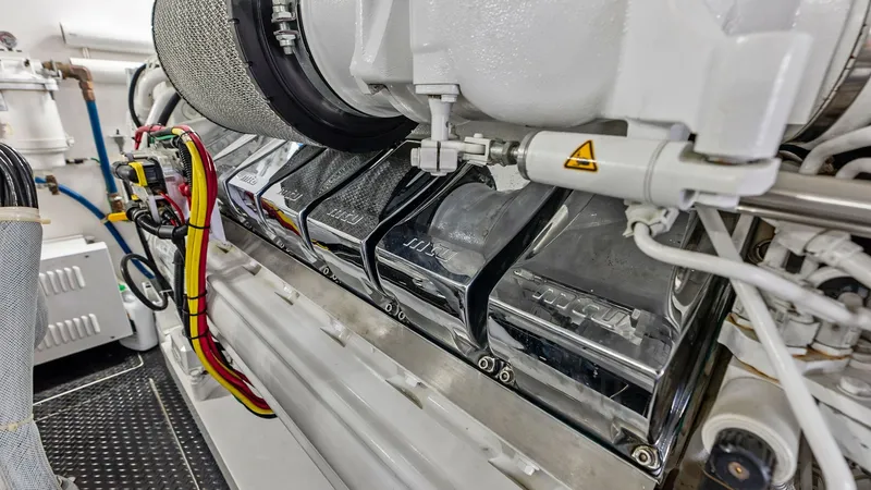 Slide: The Image of Engine Room with Advanced Machinery The engine room of the 2017 Viking 80 Convertible 'Aussie Rules' showcases a powerful and meticulously maintained engine. The polished chrome components and organized wiring highlight the vessel's commitment to performance and reliability. This space is d - 7932706