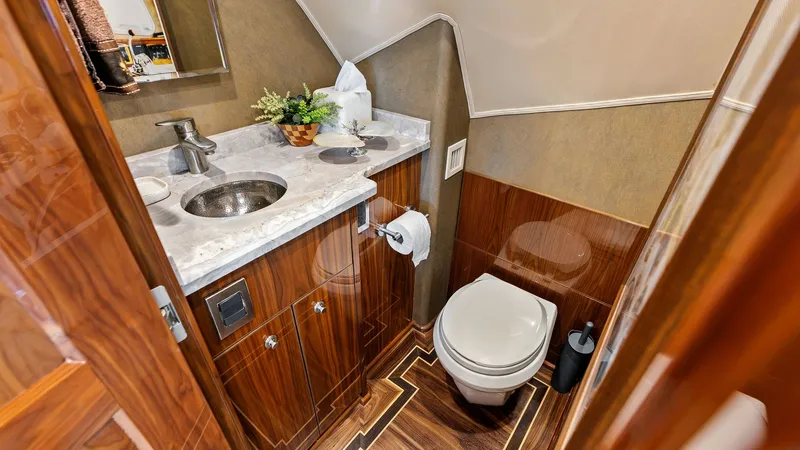 Slide: The Image of Luxurious Guest Head This elegant guest head on the 2017 Viking 80 Convertible features high-gloss wood cabinetry and a sleek marble countertop. The space is beautifully appointed with premium fixtures, ample storage, and tasteful decor, ensuring both functionality and luxury - 7932659