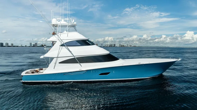 Slide: The Image of Starboard Profile of Viking 80 Convertible This image showcases the sleek starboard profile of the 2017 Viking 80 Convertible, 'Aussie Rules'. The yacht features a striking blue hull and a towering flybridge, ideal for sportfishing enthusiasts. Its elegant design is complemented by expansive windo - 7932715
