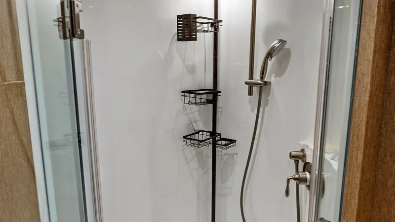 Slide: The Image of Luxurious Enclosed Shower Stall This sleek and modern enclosed shower stall on the Viking 80 Convertible features elegant chrome fixtures and ample storage space with multiple caddies for toiletries. The glass door adds a touch of sophistication, while the high-quality finishes ensure d - 7932667