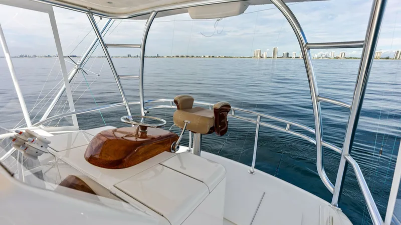 Slide: The Image of Flybridge Helm with Ocean View The flybridge helm offers an expansive view of the open ocean, framed by sleek stainless steel supports. The polished wooden helm station provides a touch of elegance, complemented by a comfortable, adjustable captain's chair. This elevated position ensur - 7932691