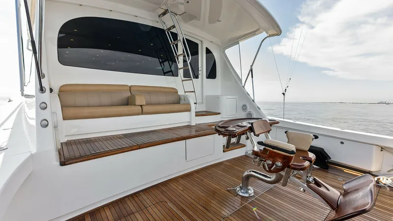 Slide: The Image of Spacious Aft Deck with Fishing Chair The aft deck of the 2017 Viking 80 Convertible 'Aussie Rules' features a beautifully finished teak deck, offering ample space for fishing or relaxation. A prominent fighting chair is centrally positioned, perfect for serious anglers. The comfortable built - 7932695