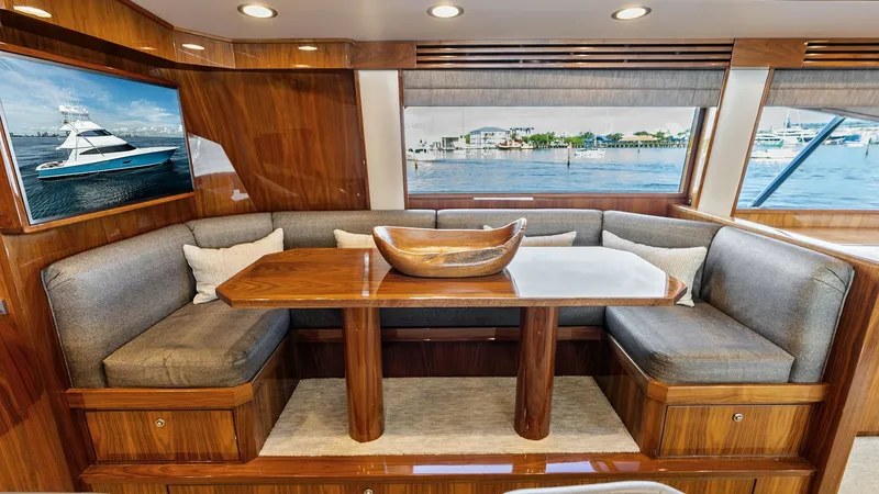 Slide: The Image of Elegant Salon Dinette Area This cozy salon dinette on the 2017 Viking 80 Convertible features luxurious wood finishes and plush seating, offering a comfortable space for dining and relaxation. Large windows provide ample natural light and stunning views, enhancing the open feel of - 7932657