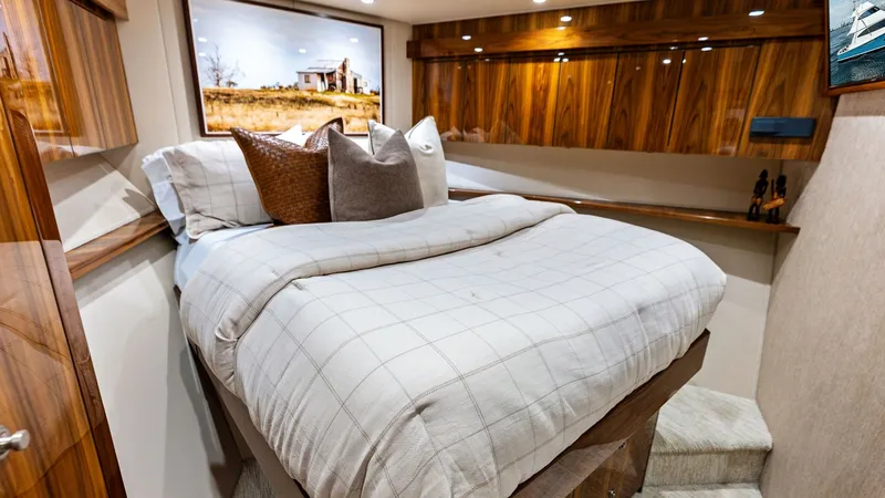 Slide: The Image of Guest Stateroom with Queen Berth This inviting guest stateroom features a plush queen-sized berth with elegant bedding, offering comfort and style. Rich wooden cabinetry provides ample storage while enhancing the luxurious ambiance. Soft, recessed lighting and tasteful artwork complete t - 7932677