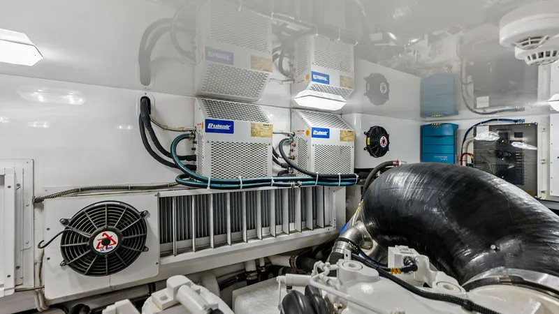 Slide: The Image of Engine Room with Mechanical Systems This image showcases the well-organized engine room of the Viking 80 Convertible, featuring advanced mechanical systems. Prominent are the dual Dometic air conditioning units, providing efficient climate control for the vessel. The space is meticulously a - 7932714