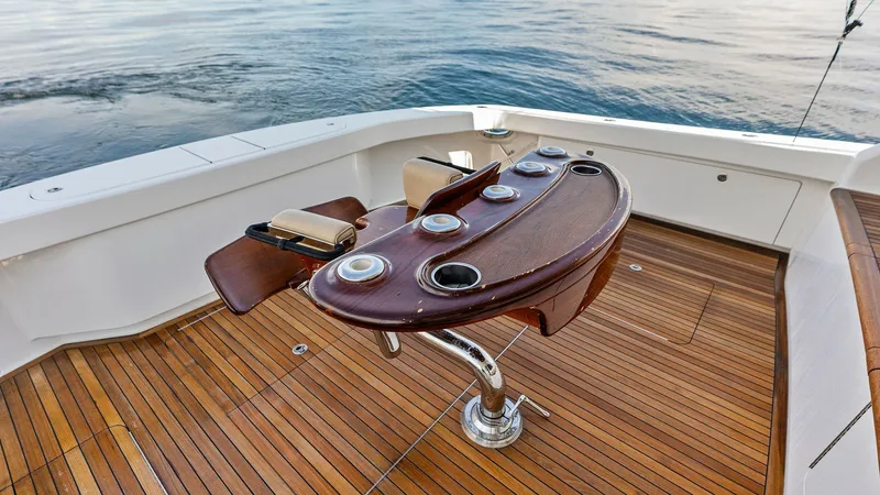 Slide: The Image of Teak Cockpit with Fishing Chair The spacious cockpit features elegant teak decking and a robust fishing chair, ideal for sportfishing enthusiasts. The chair is equipped with multiple rod holders and a polished finish, ensuring both functionality and style. The surrounding open space pro - 7932697