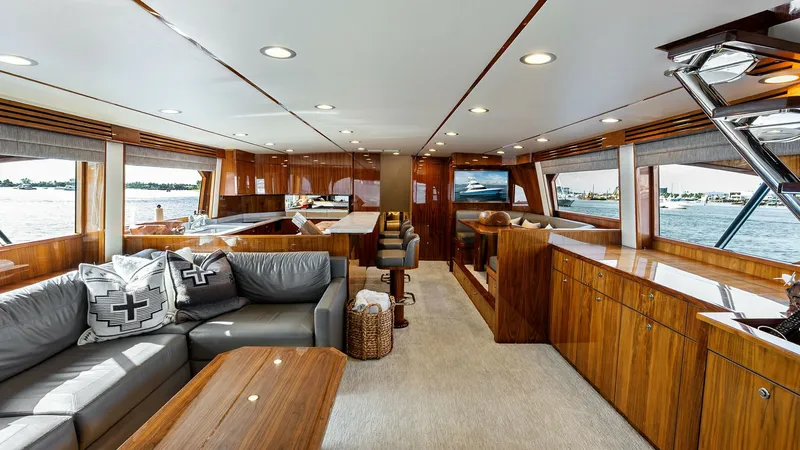 Slide: The Image of Spacious Salon with Panoramic Views The salon of the 2017 Viking 80 Convertible showcases elegant wood finishes and ample natural light. Large windows provide stunning panoramic views, while the plush seating and sophisticated decor create a comfortable and inviting atmosphere. Modern reces - 7932650