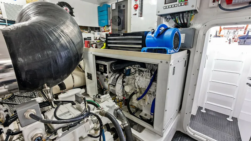 Slide: The Image of Engine Room with Generator The engine room of the 2017 Viking 80 Convertible showcases advanced machinery, including a powerful generator unit. The space is meticulously organized, featuring high-quality components and efficient cable management. Bright lighting and durable materia - 7932711